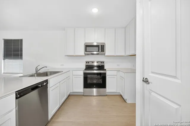 a kitchen with granite countertop a stove top oven sink and cabinets