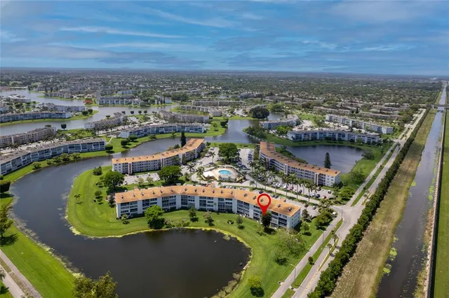 an aerial view of a house with a garden and lake view