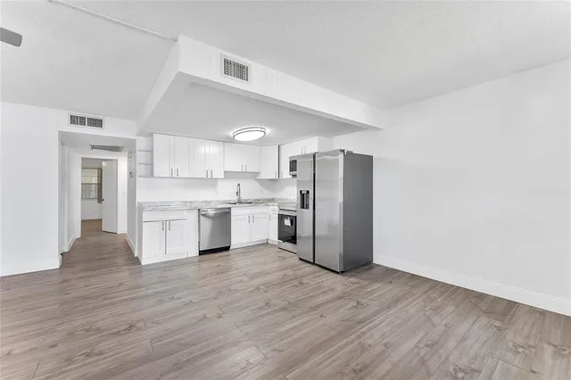 a kitchen with stainless steel appliances a refrigerator sink and cabinets
