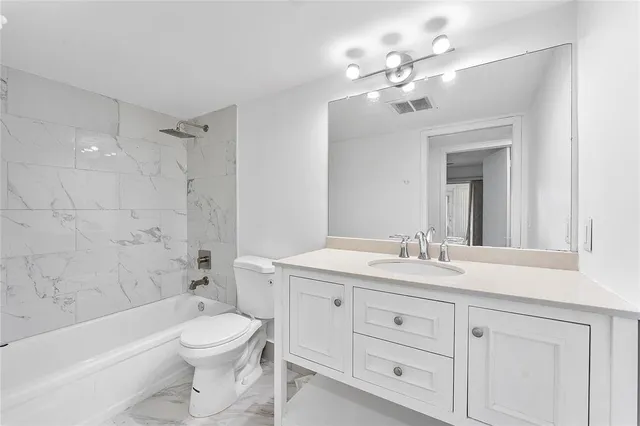 a bathroom with a toilet a sink a large mirror and shower