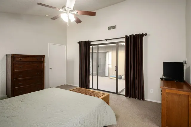 a bedroom with a bed and a flat tv screen on dresser