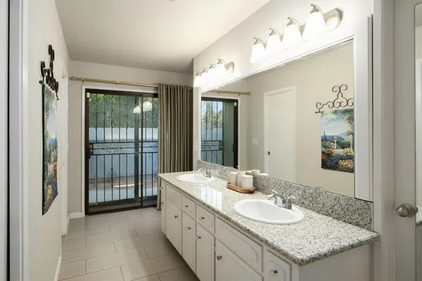 a bathroom with a granite countertop sink and a mirror
