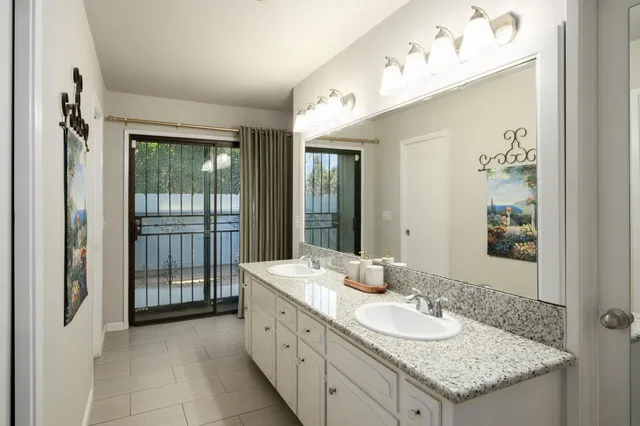 a bathroom with a granite countertop sink and a mirror