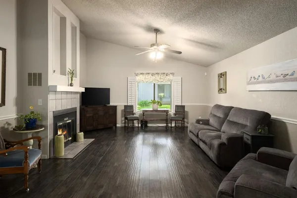 a living room with furniture a fireplace and a flat screen tv
