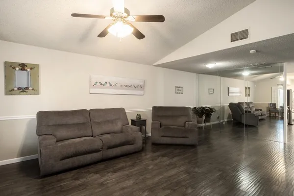a living room with furniture and a ceiling fan