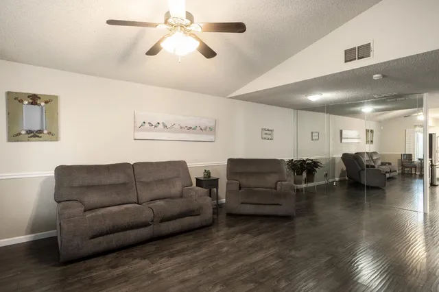 a living room with furniture and a ceiling fan