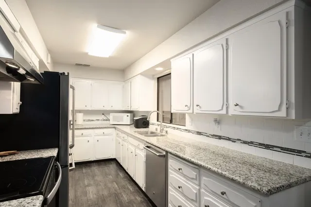 a kitchen with a sink stove and cabinets