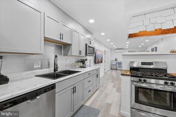 a kitchen with stainless steel appliances granite countertop a sink a stove and cabinets