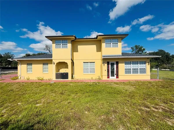 a front view of a house with a big yard