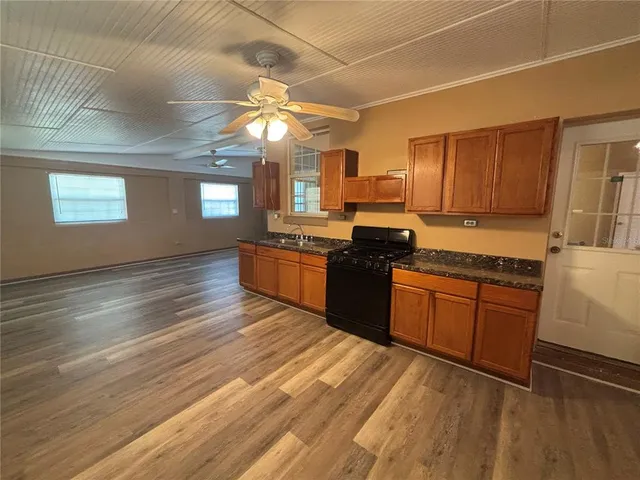 a large kitchen with cabinets wooden floor and stainless steel appliances