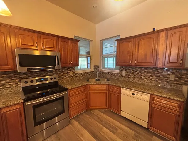 a kitchen with stainless steel appliances a stove sink microwave and cabinets