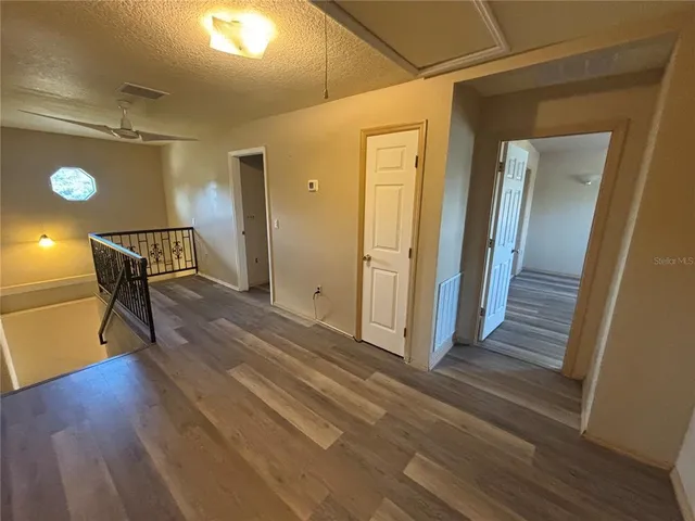 a view of a hallway with wooden floor and furniture