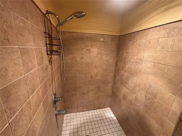 an empty room with wooden floor ceiling fan and windows