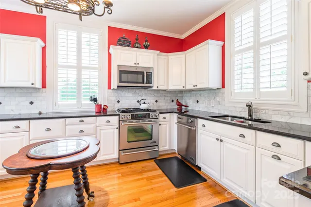 a kitchen with stainless steel appliances granite countertop a stove a sink and a microwave