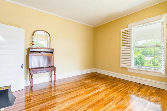 a view of a room with wooden floor and window