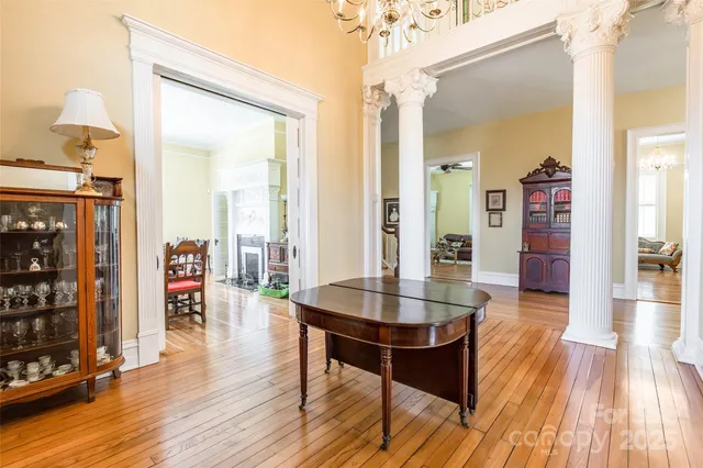 a dining room with wooden floor glass table and chairs