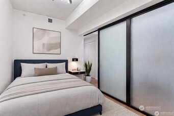 450 South Main Street, Unit 1005 Seattle, WA 98104 - Photo 23 of 33 a bedroom with a large bed and a painting on the wall