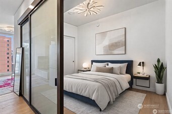 450 South Main Street, Unit 1005 Seattle, WA 98104 - Photo 24 of 33 a bedroom with a large bed and a chandelier