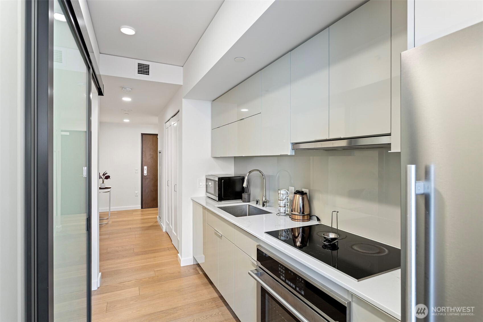 450 South Main Street, Unit 1005 Seattle, WA 98104 - Photo 29 of 33 a kitchen with a sink a stove and cabinets