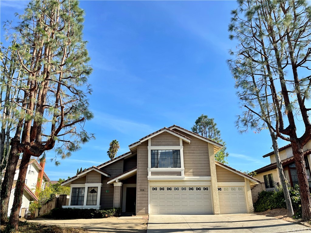 a front view of a house with a tree