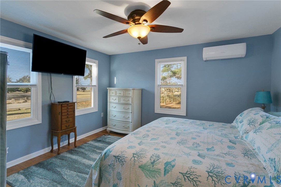 4462 Windmill Point Road White Stone, VA 22578 - Photo 14 of 29 a bedroom with a bed and a television with wooden floor