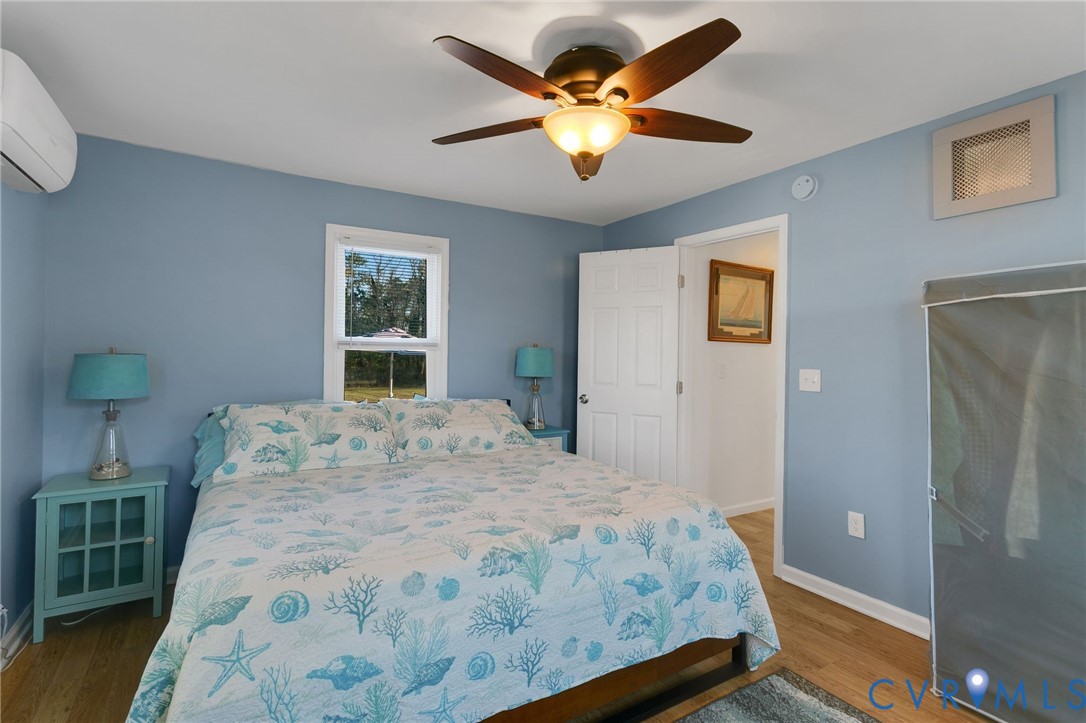 4462 Windmill Point Road White Stone, VA 22578 - Photo 15 of 29 a bedroom with a bed and a chandelier