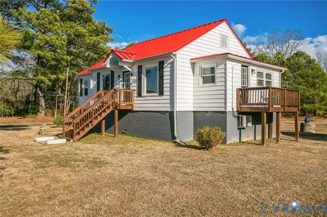 a view of a house with a yard and wooden fence