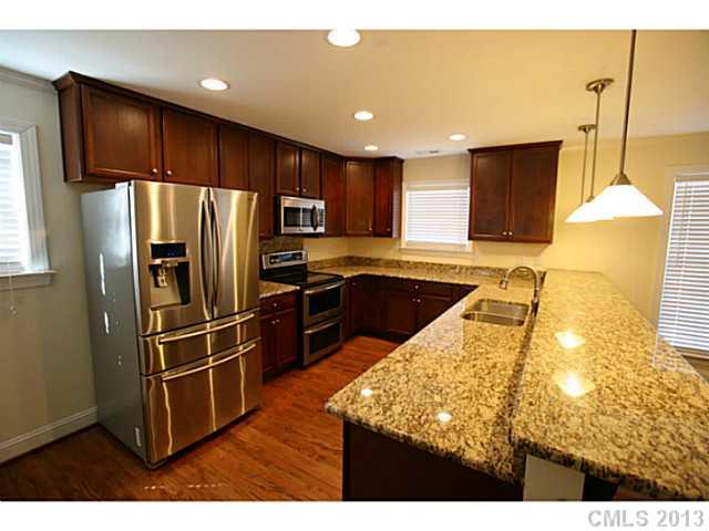 6441 Stirewalt Road Kannapolis, NC 28081 - Photo 5 of 16 a kitchen with kitchen island granite countertop wooden cabinets a refrigerator and a sink