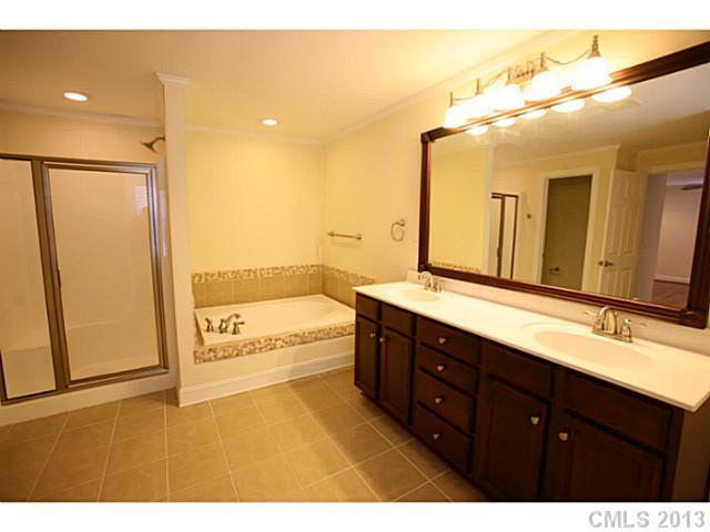 6441 Stirewalt Road Kannapolis, NC 28081 - Photo 10 of 16 a bathroom with a tub a double vanity sink and mirror
