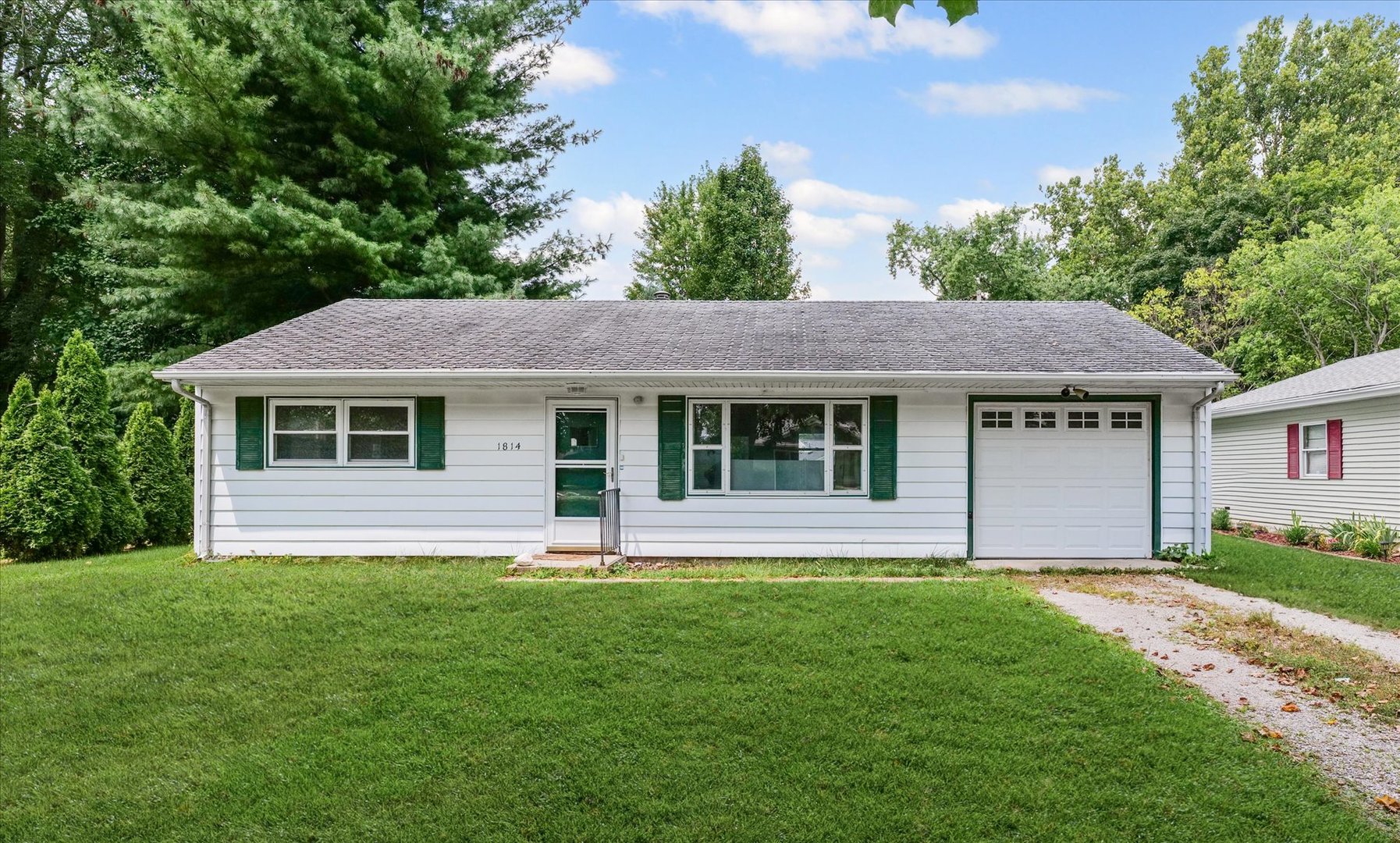 a front view of a house with a garden and plants