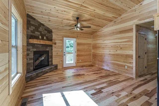 a view of an empty room with a fireplace and a window