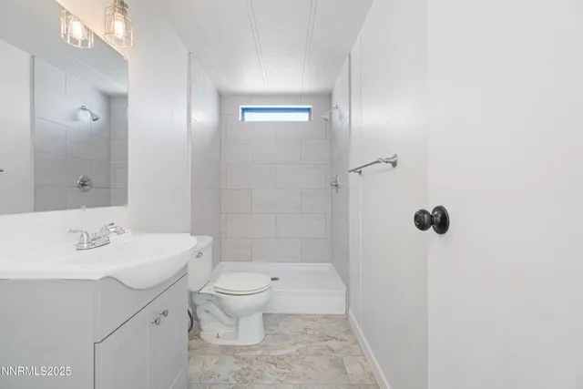 a bathroom with a sink a toilet a mirror and shower