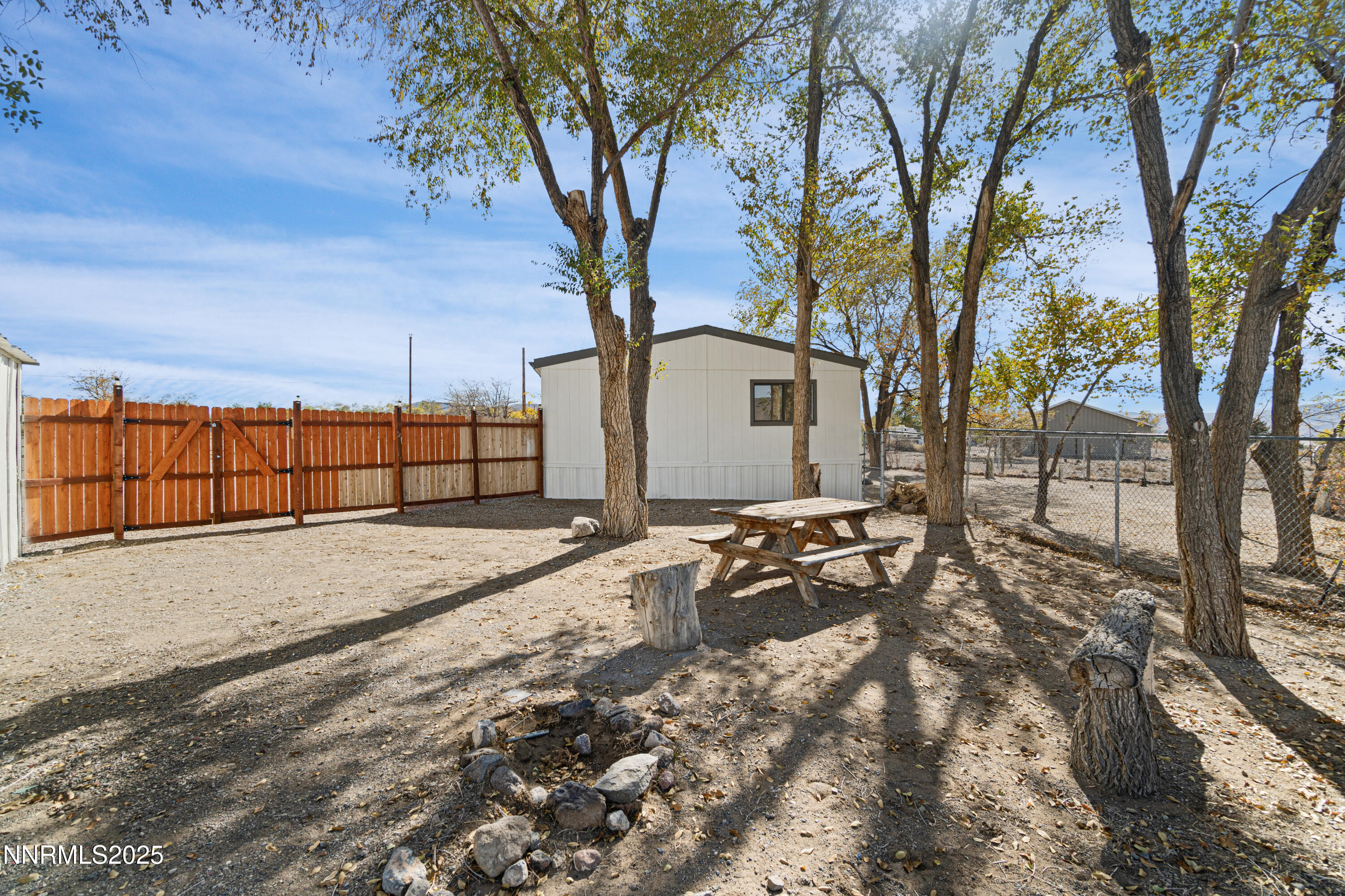 4915 Cheyenne Trail Stagecoach, NV 89429 - Photo 24 of 26 a view of backyard with large trees and wooden fence