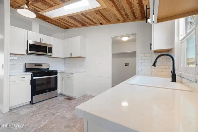 a kitchen with stainless steel appliances a stove a sink a microwave and cabinets