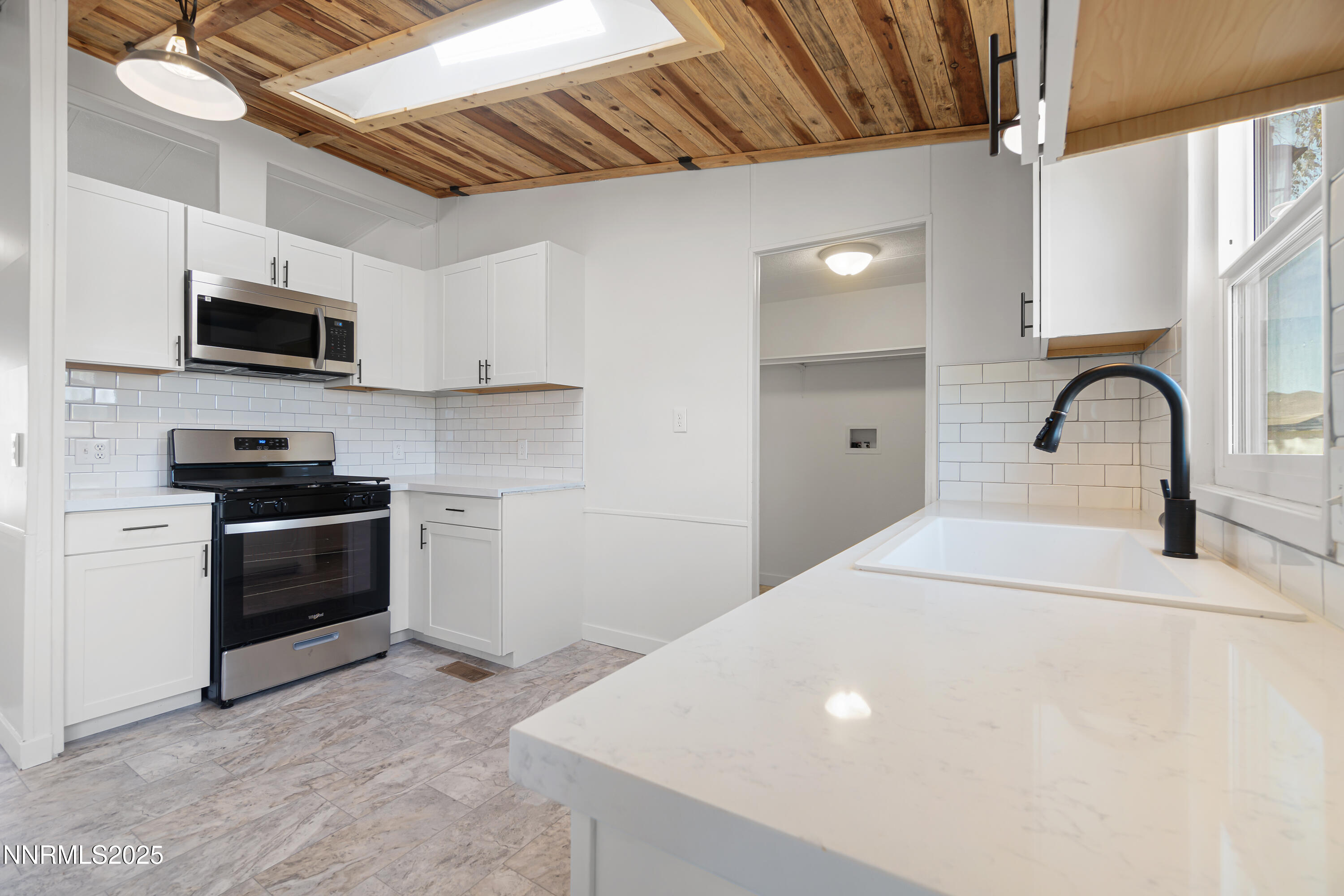 4915 Cheyenne Trail Stagecoach, NV 89429 - Photo 7 of 26 a kitchen with stainless steel appliances a stove a sink a microwave and cabinets
