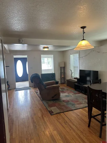 a living room with furniture and a wooden floor