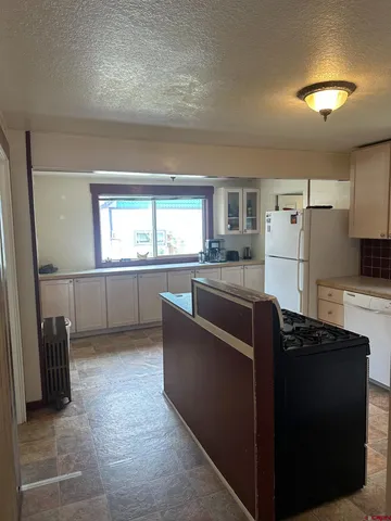 a kitchen with granite countertop a refrigerator and a sink
