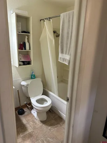 a bathroom with a toilet and a shower