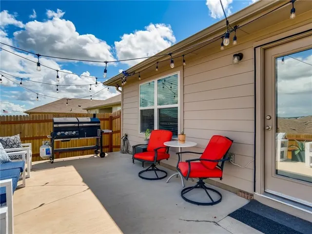 a patio with lawn chairs and a barbeque