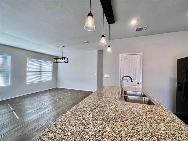 a kitchen with a refrigerator and chandelier
