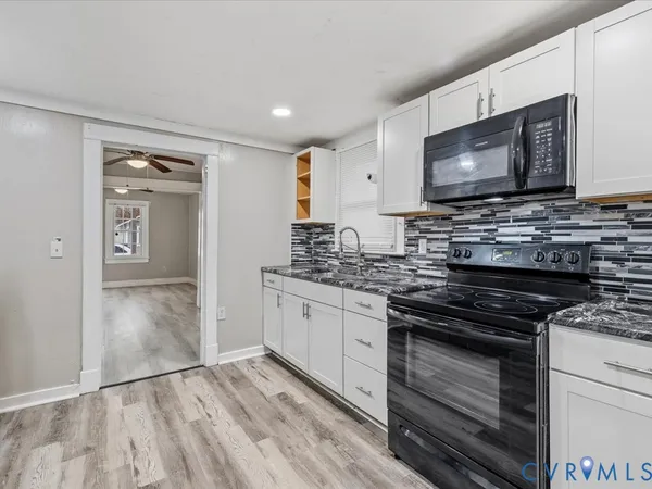 a kitchen with granite countertop a stove and a sink