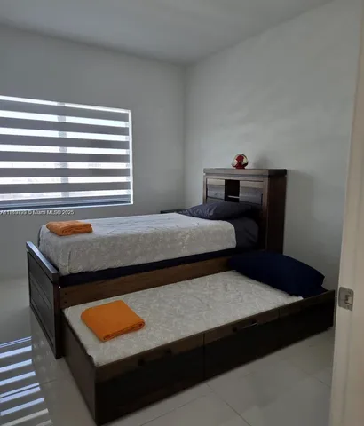 a bedroom with a bed lamp and window