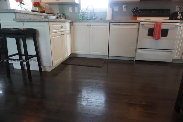 a kitchen with stainless steel appliances kitchen island granite countertop a refrigerator and microwave