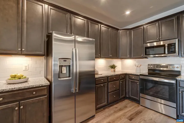 a kitchen with a sink and a stove with wooden floor