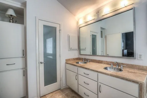 a bathroom with a granite countertop sink double and mirror