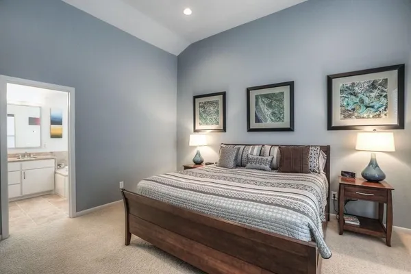 a bedroom with a bed and a lamp on the dresser