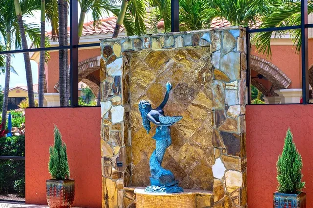 a view of a swimming pool with a lawn chairs under palm tree