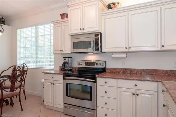 a kitchen with granite countertop white cabinets and stainless steel appliances