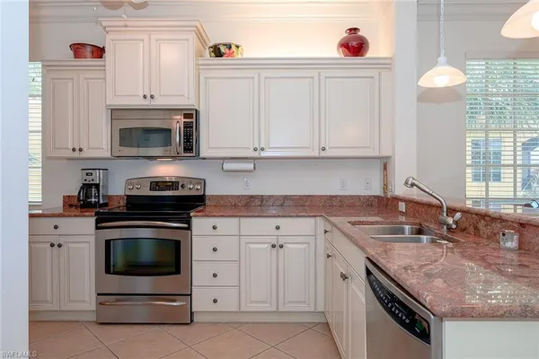 a kitchen with granite countertop a sink stove and cabinets