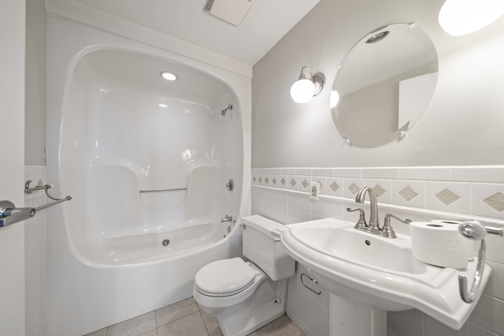 155 George Washington Boulevard, Unit 402 Hull, MA 02045 - Photo 19 of 42 a bathroom with a toilet sink and mirror